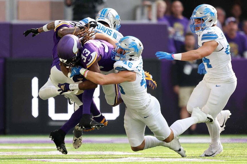 Aaron Jones #33 of the Minnesota Vikings is tackled by Jack Campbell #46 of the Detroit Lions.