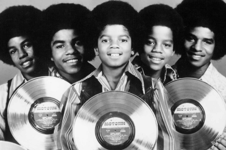 The Jackson 5 smile with vinyl records.