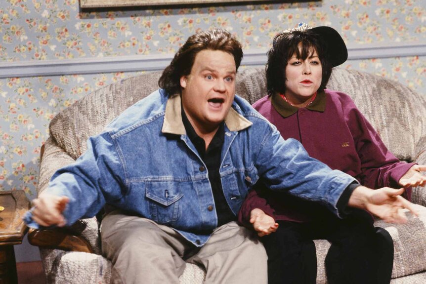 Tom Arnold (Chris Farley) holds out his hands in ridicule next to Roseanne (Victoria Jackson) during a SNL sketch,