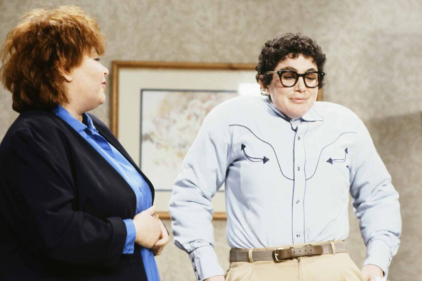 Sue (Roseanne Barr) looks at a nerdily dressed Pat (Julia Sweeney) during an SNL sketch.