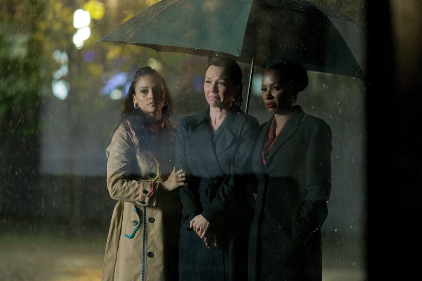 Margaret (Kelli Williams), Lacey (Gabrielle Walsh), and Gabi (Shanola Hampton) stand under an umbrella on Found Episode 206.