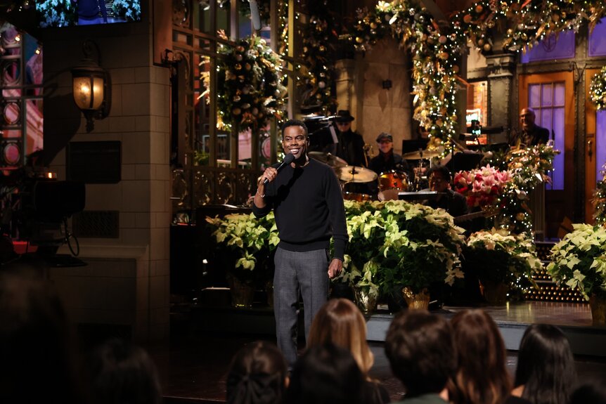 Chris Rock holding a microphone onstage.