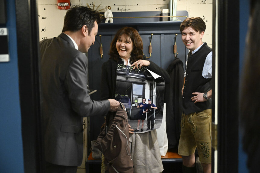 Jimmy Fallon talking and looking a printed photo with the Ewerdwalbesloh family.