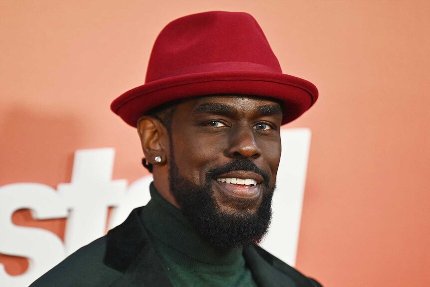 Mustafa Shakir smiling at the premiere of Ghosted at AMC Lincoln Square.