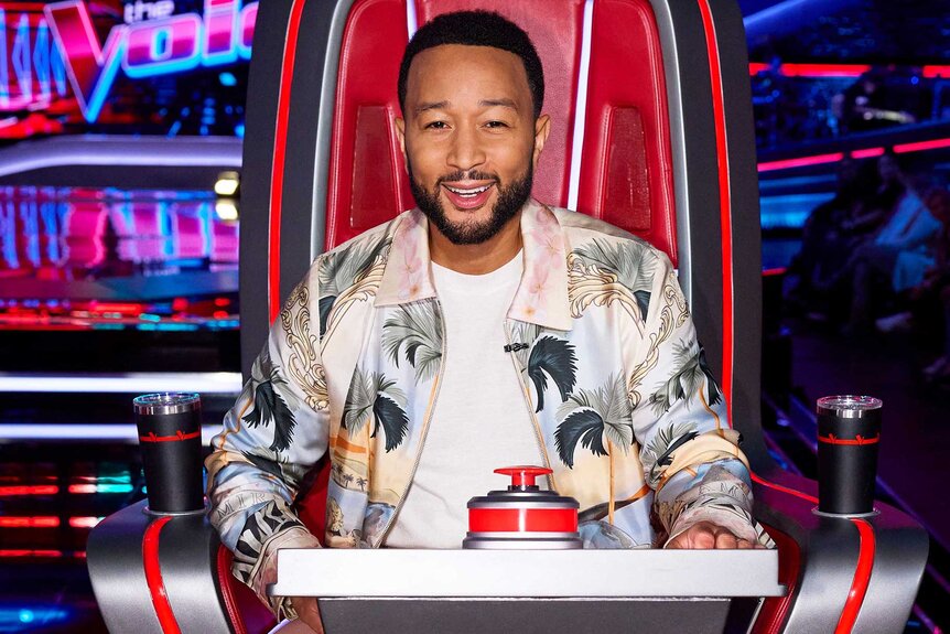 John Legend smiling in the judges chair on The Voice Season 27, Episode 1.