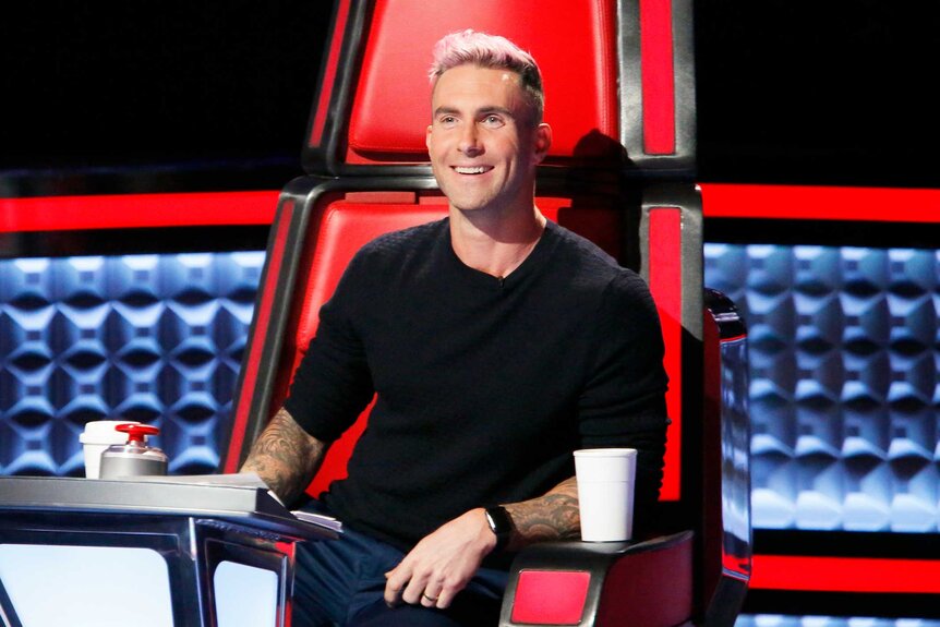 Adam Levine smiles with pink hair on the voice Season 10