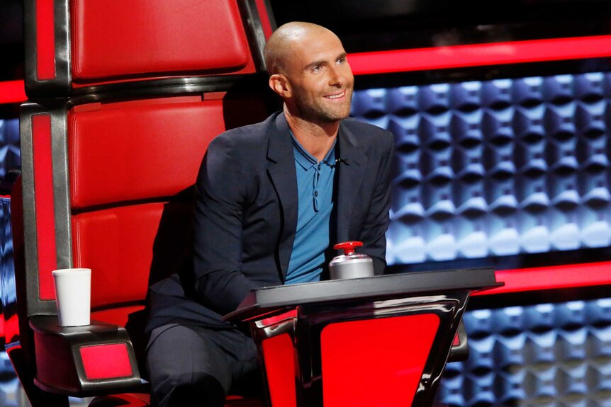 Adam Levine leans over to talk to a contestant on The Voice Season 9