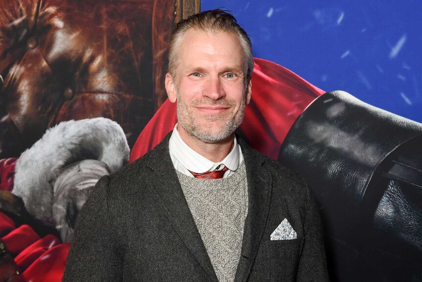 André Eriksen posing and smiling at the premiere of Violent Night.