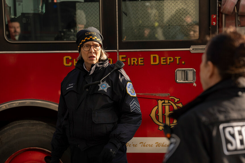 Trudy Platt looks concerned in front of a fire truck on Chicago Fire Season 13 Episode 11.