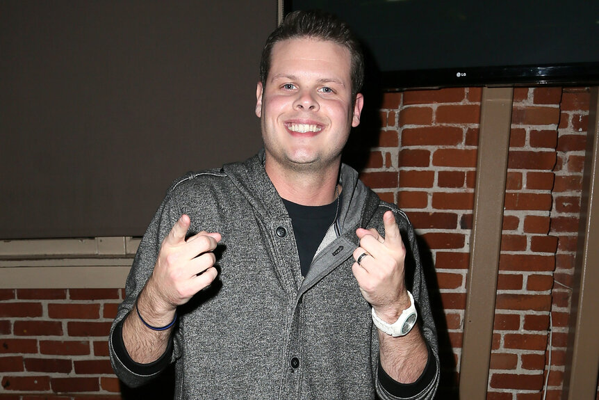 Derrick Levasseur points his fingers towards the camera at an event celebrating big brother