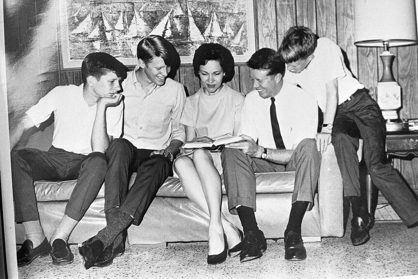 Jimmy Carter and Rosalynn Carter look through a photo book with their three children, Chip, Jack and Jeff.