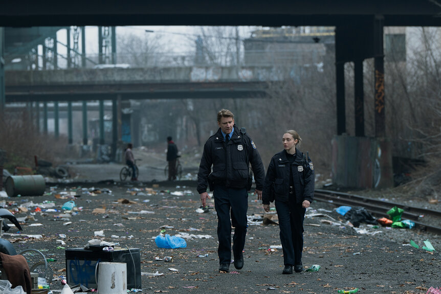 Lafferty and Mickey walk outside around a bunch of garbage in Long Bright River Season 1, Episode 1.