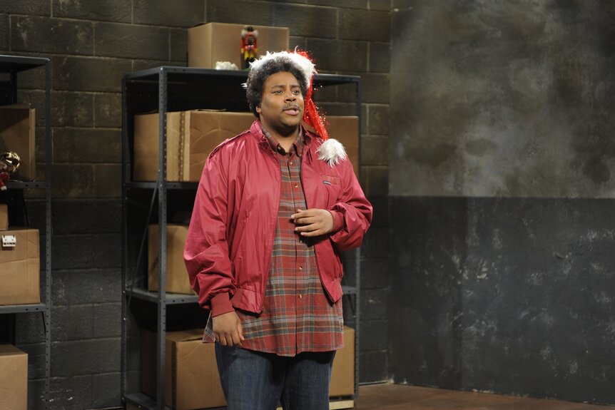 Kenan Thompson wears a santa hat and red holiday outfit on SNL Episode 1542.