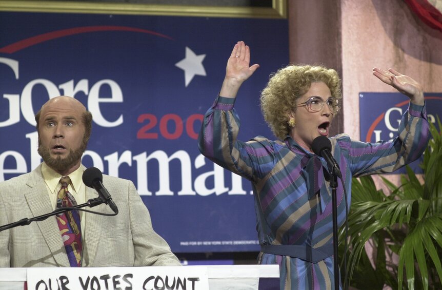 Marty Culp (Will Ferrell) and Bobbi Mohan-Culp (Ana Gasteyer) speak at a political rally during SNL Episode 2605.