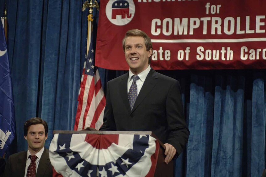 Richard Eckstrom (Jason Sudeikis) stands at a podium on SNL Episode 3201.