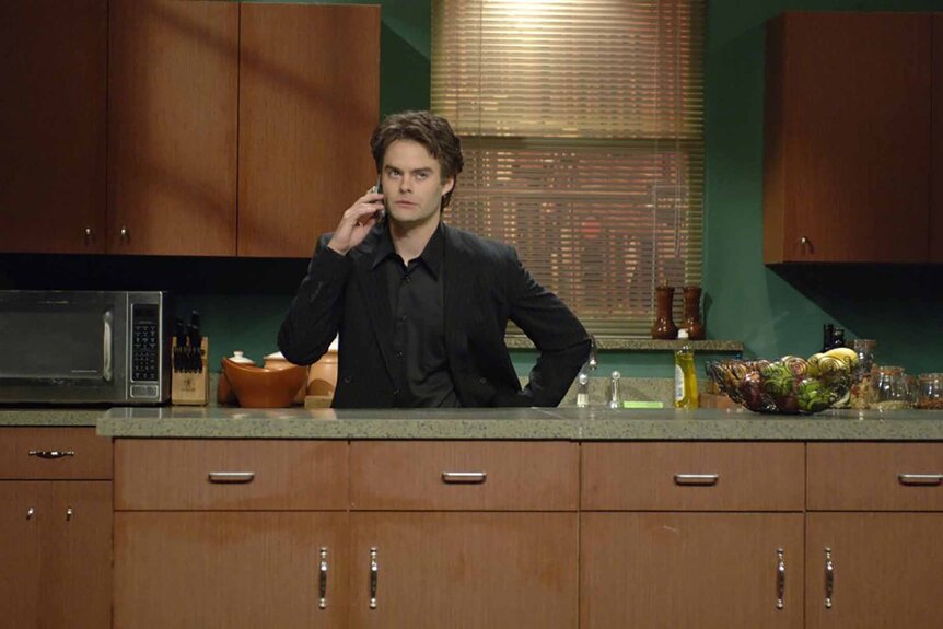 Al Pacino (Bill Hader) speaks on a cellphone in a kitchen on SNL Episode 3201.