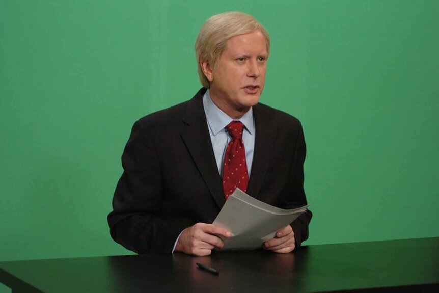 Chris Matthews (Darrell Hammond) wears a suit and sits in front of a green schreen on SNP Episode 3204.