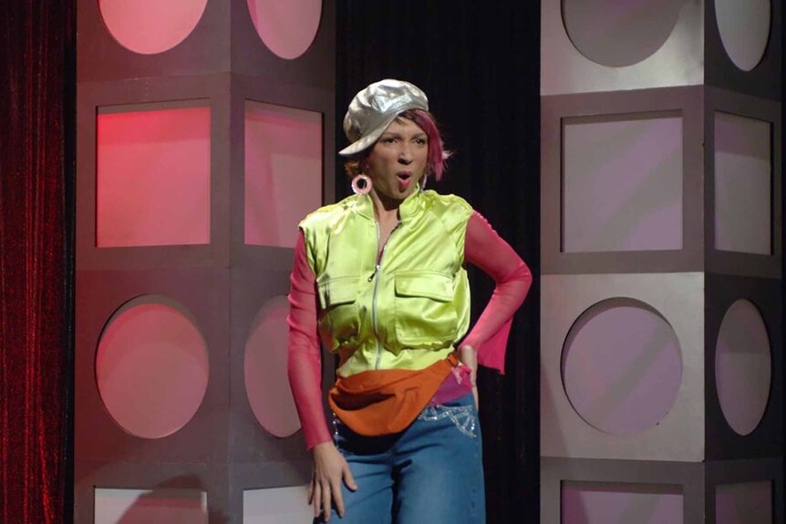 Tuhnay Griggs (Maya Rudolph) wears a silver hat, neon yellow vest, and orange fanny pack on SNL Episode 3210.