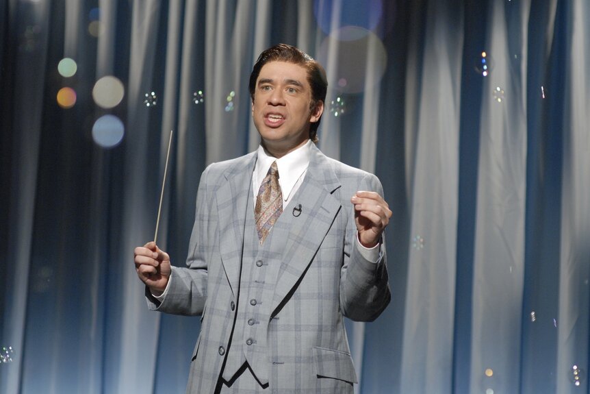 Lawrence Welk (Fred Armisen) wears a grey suit on SNL Episode 3422.