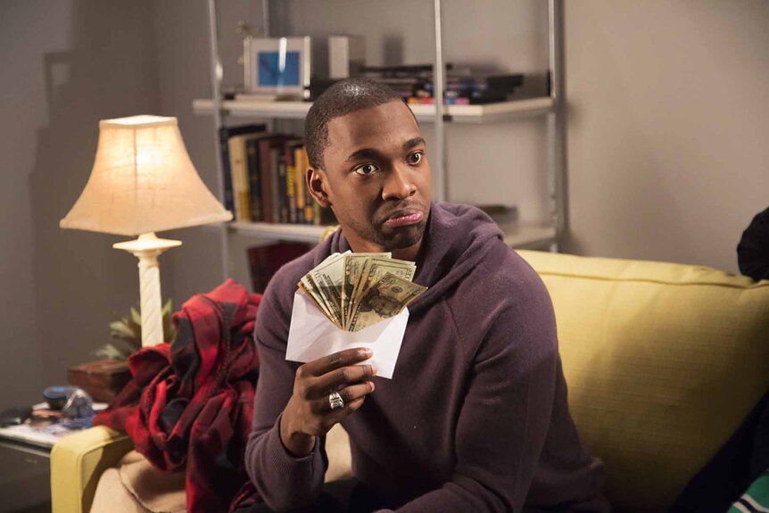 Jay Pharoah holds an envelope full of money in SNL Episode 1671.