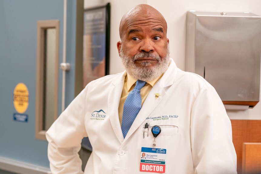 Dr. Ron (David Alan Grier) smirks in a white doctor's coat on St. Denis Medical Episode 108.