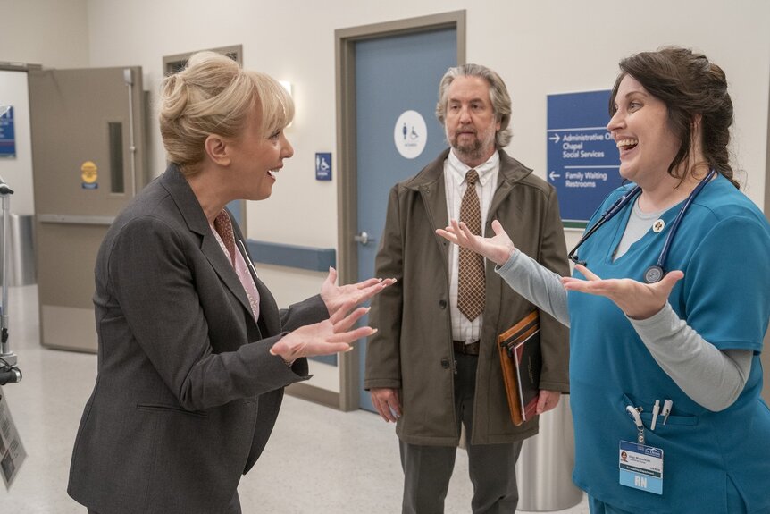 Notery (Steve Little) watches as Joyce (Wendi Mclendon Covey) and Alex (Allison Tolman) chat in a hallway.