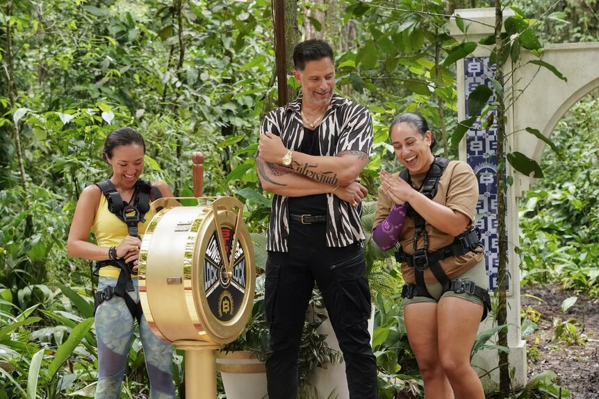 Courtney "CK" Kim, Joe Manganiello, and Seychelle Cordero smile in front of a golden lever on Deal or No Deal Island Episode 205.