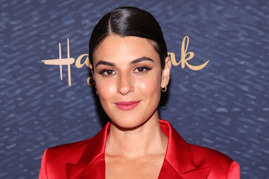 Sara Garcia wears a red dress on the red carpet at an event