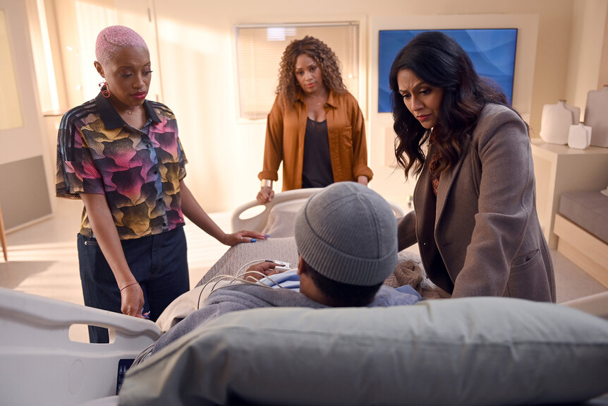 Marisa Kylie and Rose all talk to alec in a hospital bed in The Irrational Season 2, Episode 9.