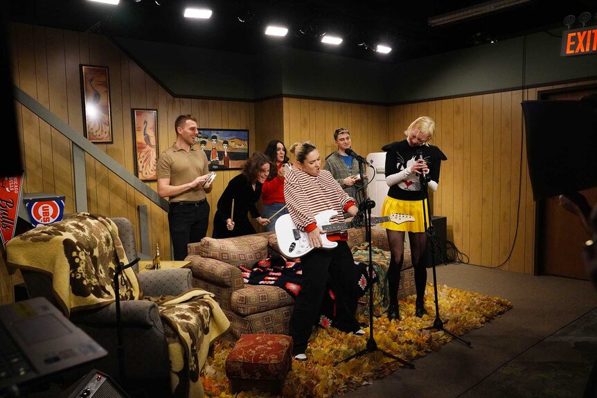 Guests on the Wayne's World set playing guitars and singing in the Live from New York: The SNL50 Experience VIP Preview.