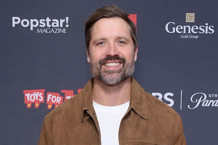 Walker Hayes smiles in a brown jacket on the red carpet