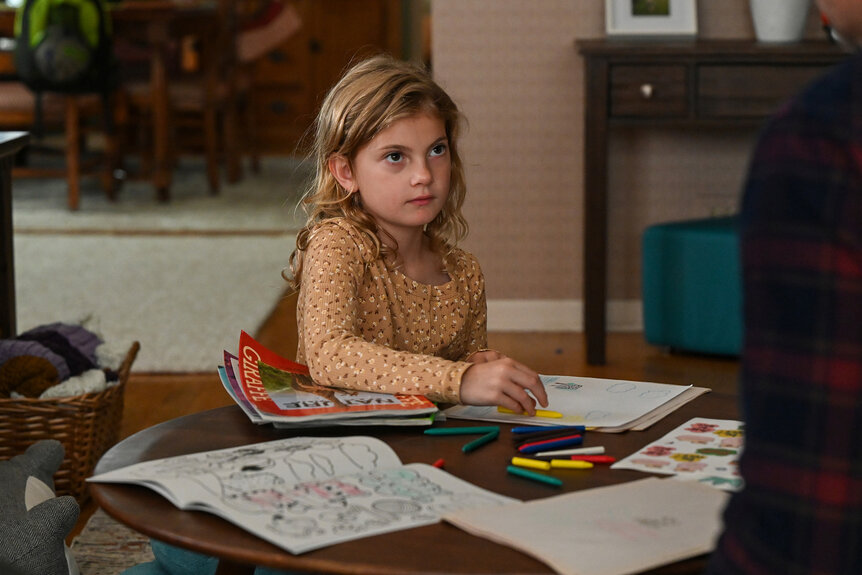 Zoe colors at a table on Chicago P.D Season 12, Episode 10.