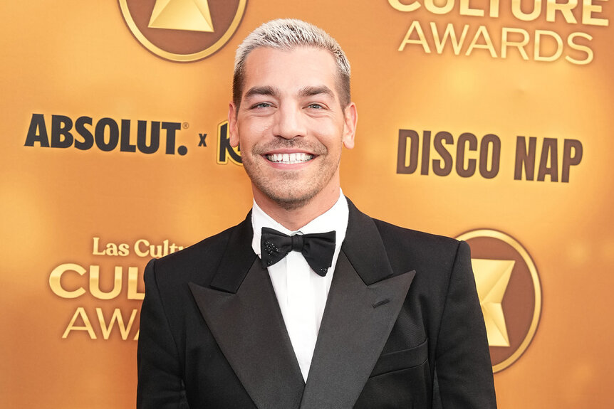 Matt Rogers smiles in a tuxedo.