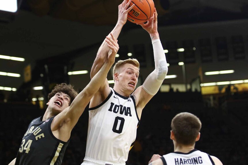 ven Brauns #0 of the Iowa Hawkeyes grabs the ball as Raleigh Burgess #34 of the Purdue Boilermakers reaches to block him.