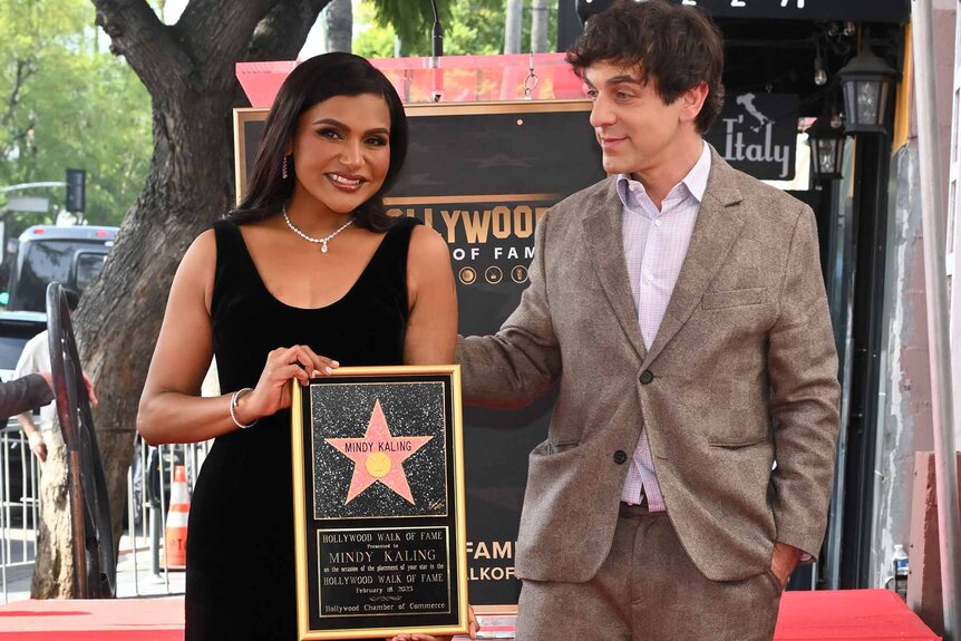 B.J. Novak admires Mindy Kaling holding her plaque at her Hollywood Walk Of Fame star ceremony.