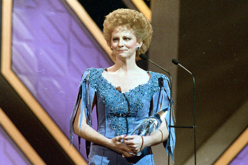 Reba McEntire tearfully accepts the award for "Entertainer of the Year" during Country Music Association awards.