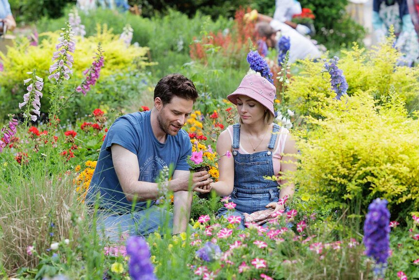 Brett and Alice together in a garden in Grosse Pointe Garden Society Season 1, Episode 1.