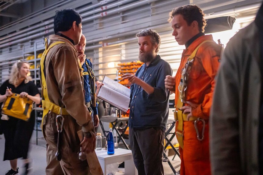 Simu Liu, Woody Harrelson, Finn Cole, and Alex Parkinson talking on the set of Last Breath (2025).