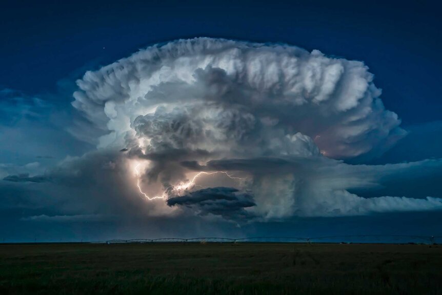 A large lightning storm in a huge field.