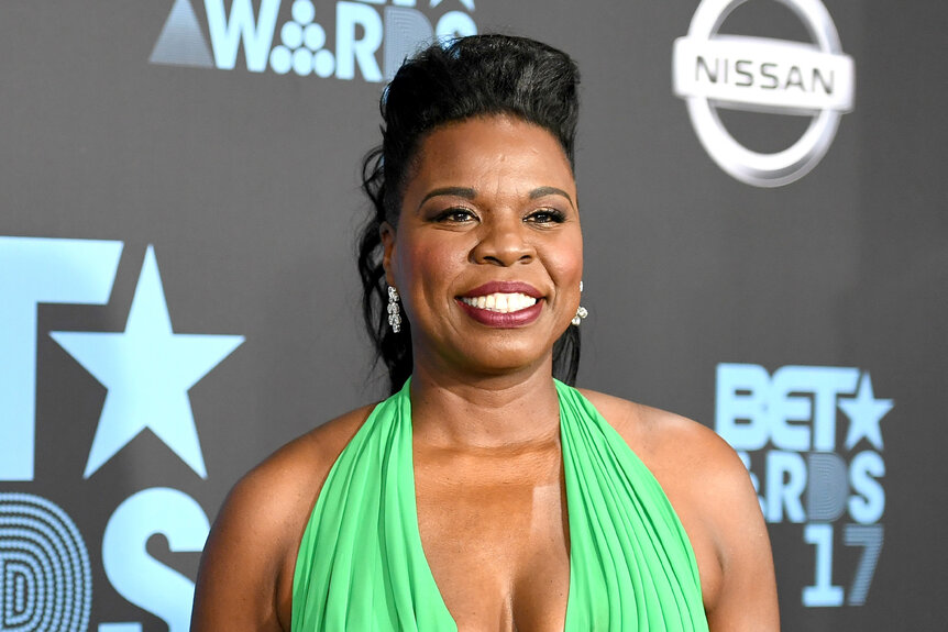 Leslie Jones smiles in a green halter dress.