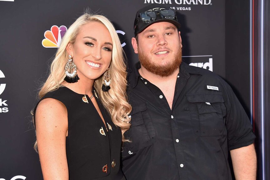 Luke Combs and wife Nicole Hocking smiling and posing at the 2018 Billboard Music Awards.