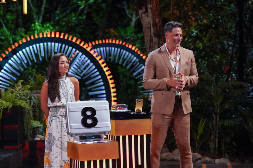 Courtney Kim and Joe Manganiello stand next to Briefcase 8 on Deal or No Deal Island Season 2 Episode 6.