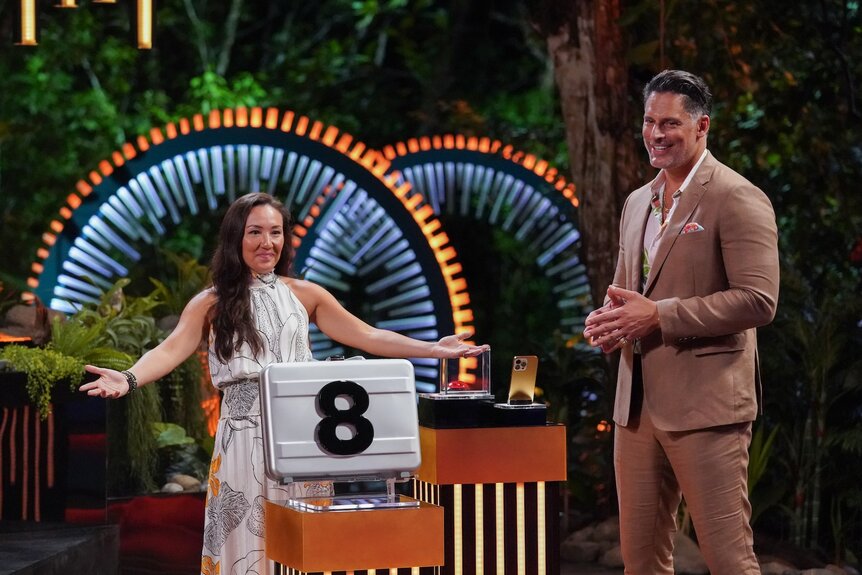 Courtney “CK” Kim and Joe Manganiello stand next to an "8" briefcase on Deal or No Deal Island Episode 207.