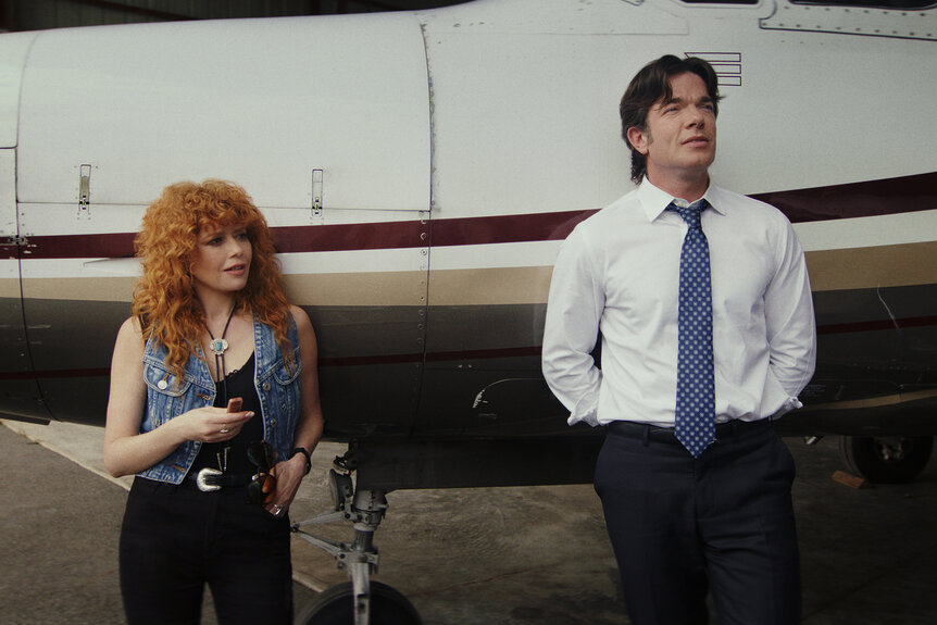 Charlie and Daniel Clyde Otis lean against a plane in Poker Face Season 2.