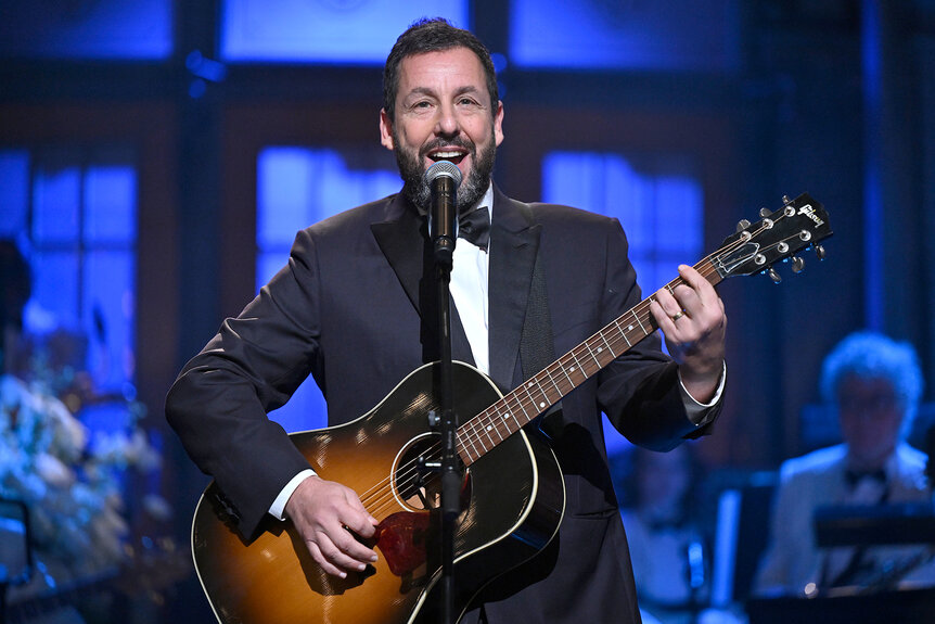 Adam Sandler sings and plays guitar on stage during Snl50: The Anniversary Special