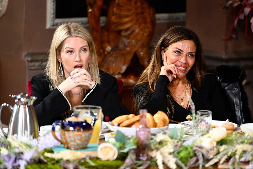 Britney Haynes and Dolores Catania at a table with food on The Traitors Season 3, Episode 10.