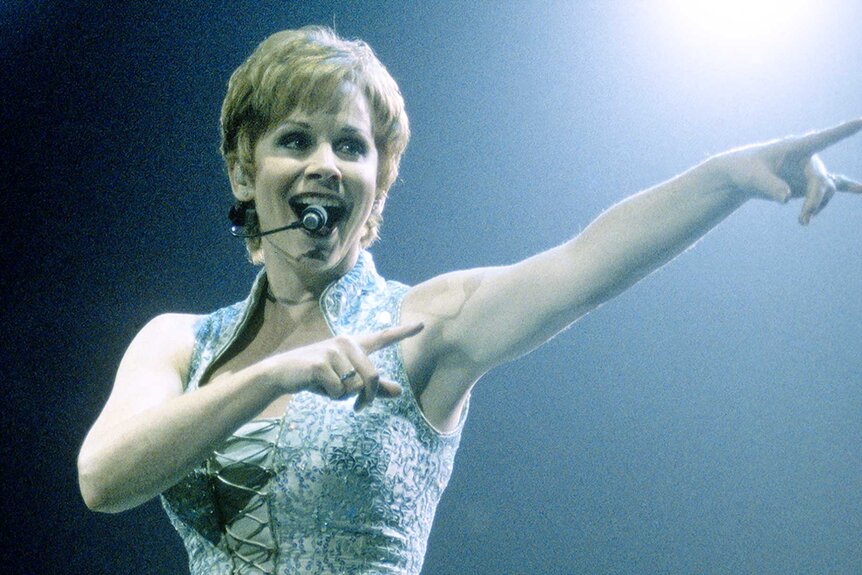 Reba McEntire sports a short hair cut while performing on stage.