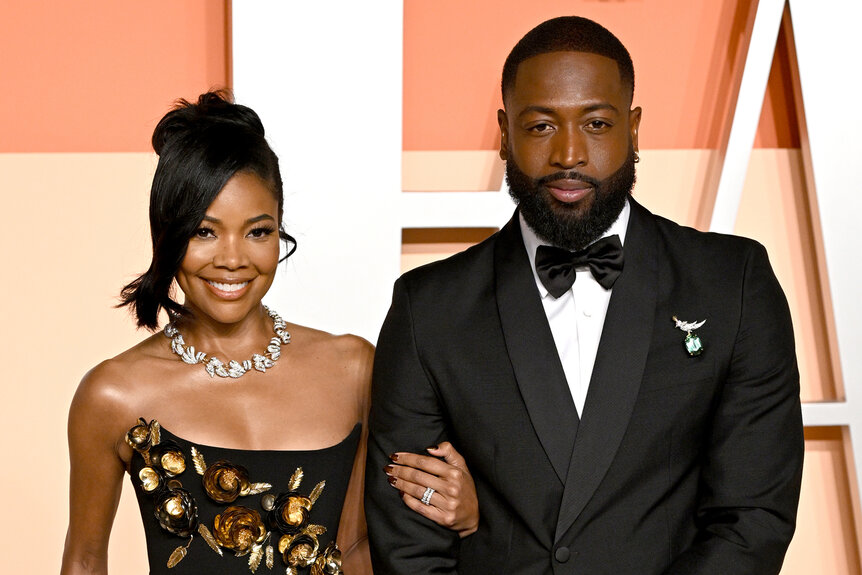 Gabrielle Union and Dwayne Wade smile together on the red carpet at the Vanity Fair Oscar Party