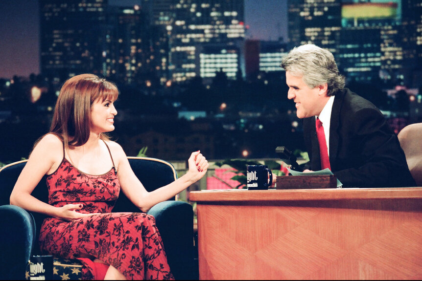 Mariska Hargitay wears a red floral dress and is interviewed by Jay Leno.