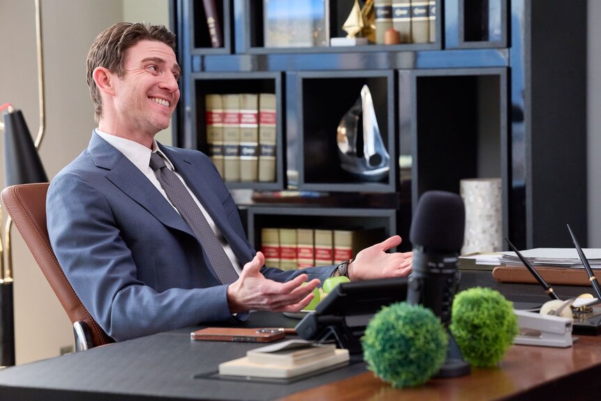 Rick Dodson (Bryan Greenberg) sits at a desk in Suits L.A. Episode 104.